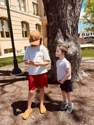 Grandkids Charlie and Simon play Pokémon Go on the Square.