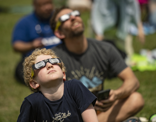 9-year-old Murad Hussein, front, and his father Ahmad Hussein (in back) view the sky on Monday.
