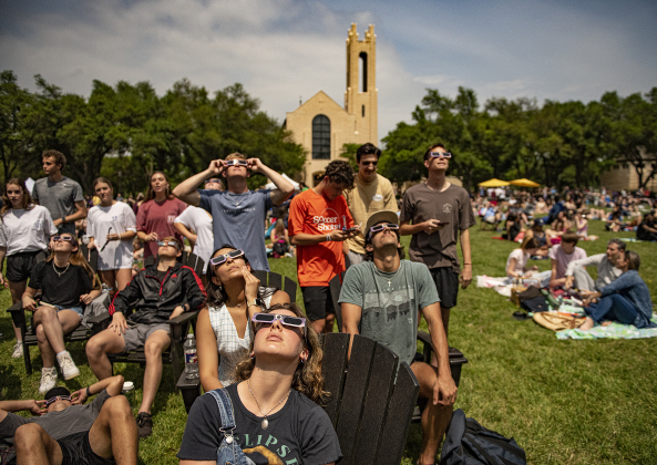Southwestern University student Katelin Pilarski, front, joins fellow classmates to view the darkening skies on Monday, April 8, during a total eclipse event held at the Southwestern University campus.