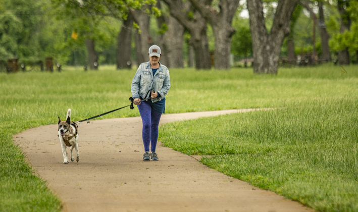 manda Williamson and her dog Stitchie-Pants walk under a canopy of pecan trees at Berry Springs Park & Preserve  with  a cooler and cloudy day  on Saturday, April 20.
