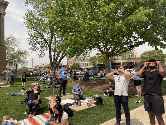 Residents gather on the Square for the April 8 eclipse. The sun shines through the clouds leading up to totality.