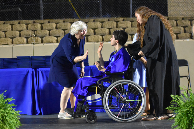 GISD trustee Stephanie Blanck presents a diploma to Shawn Eisbrenner, accompanied by GHS special education teacher Ashley Nelson.