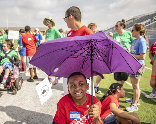 Tippit Middle School student Desi Thomas uses an umbrella to hold off the late-morning sunshine as he gets ready to join other participants in the opening parade at Birkelbach Field during the  Georgetown Independent School District's annual Special Olympics, held Tuesday, May 7, 2024  at the district sports complex behind Georgetown High School.     Photo by Andy Sharp.