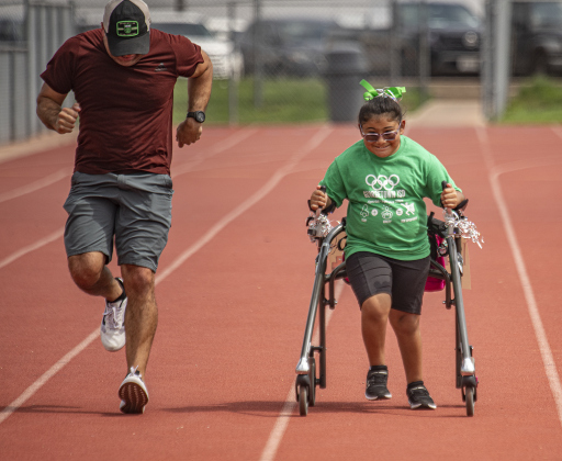 10-year-old Ari Mata, a student at Wolf Ranch Elementary, gets encouragement from her dad Rick Mata, left, during her track event at the Georgetown Independent School District's annual Special Olympics, held Tuesday, May 7, 2024  at the district sports complex behind Georgetown High School.     Photo by Andy Sharp.