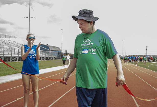 Georgetown High School student Zeke Benge is congratulated by fellow GHS student Savannah Winegar, left, as he completes a track event during the  Georgetown Independent School District's annual Special Olympics, held Tuesday, May 7, 2024  at the district sports complex behind Georgetown High School.     Photo by Andy Sharp.
