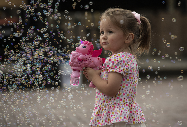  2-year-old Emilia Pustejovsky enjoys making hundreds of bubbles along West Davilla Street on Friday, May 10, 2024, the opening night of the 45th Annual Granger Lakefest.    Photo by Andy Sharp. 