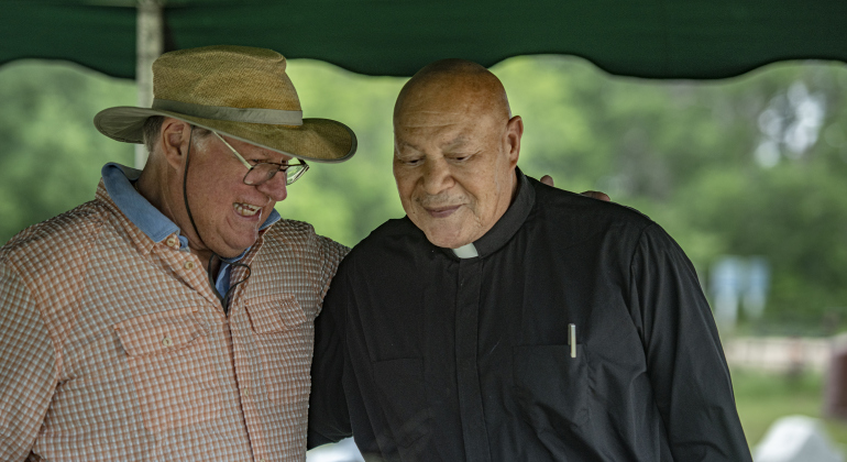 Nick Brumder, left, co-founder (with his with Ellen) of Our Lady of the Rosary Cemetery & Prayer Gardens, visits with Father Jim Robertson, a retired priest, on Saturday, April 27, 2024 to celebrate Art in the Gardens, the 20th anniversary of Our Lady.  Ellen and Nick  live in New Zealand, but return to the area occasionally.    Photo by Andy Sharp. 