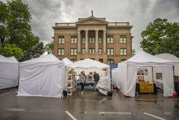 Sierra Mullan, front and her mom, Cindy Tooley, owner of Rhinestone Ranch, set up their vendor booth along Main Street on Sunday morning, April 28, 2024, the last day of the 25th Red Poppy Festival.  Rain, sometimes heavy, was the story of the day, but most vendors were able to set up shop for visitors.  Photo by Andy Sharp.