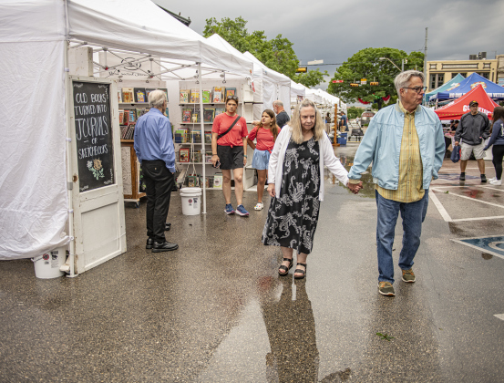 Elizabeth Byler and her husband Bill Killebrew stroll along 8th Street vendors  on Sunday morning, April 28, 2024, the last day of the 25th Red Poppy Festival.  Rain, sometimes heavy, was the story of the day, but most vendors were able to set up shop for visitors.  Photo by Andy Sharp.