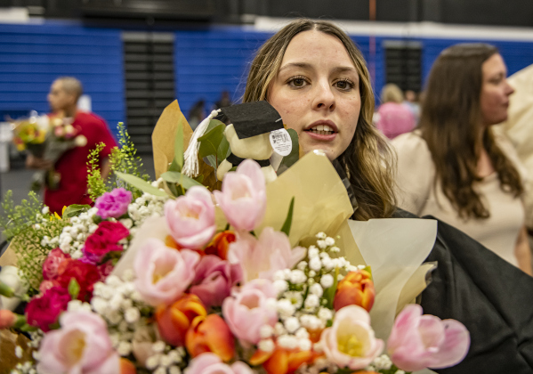 Bailey Morrow holds onto a large collection of flowers she received after graduating.