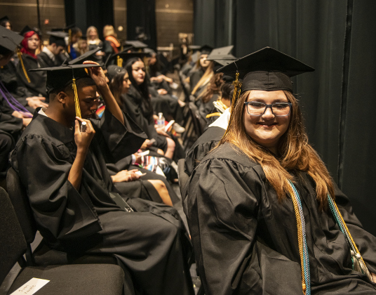 Valedictorian Lillian Troe-Beasley, right, waits with fellow graduates backstage for the start of  the 2024 Richarte High School Commencement.