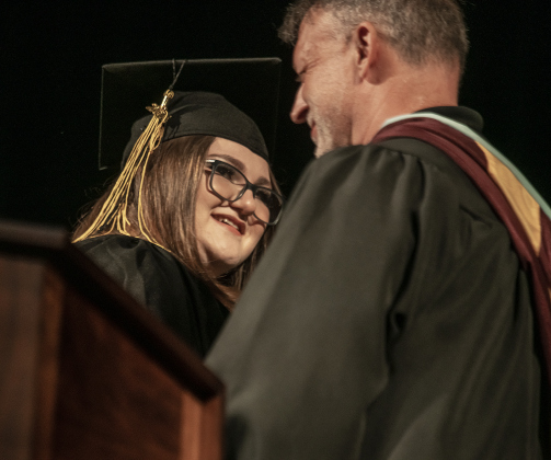 Valedictorian Lillian Troe-Beasley smiles at principal Rob Dyer after completing her valedictory speech.