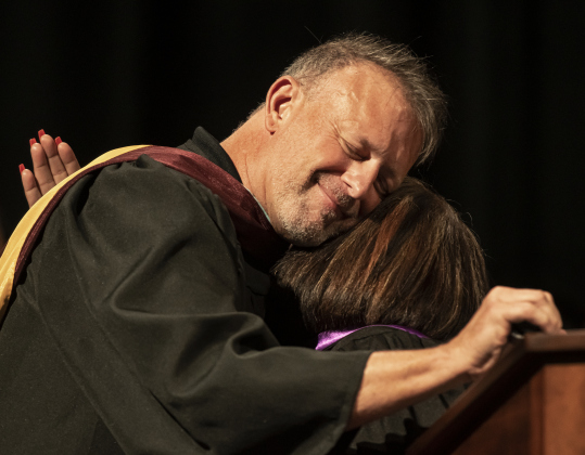 Richarte principal Rob Dyer gets a hug from teacher Lisa Nava during  the 2024 Richarte High School Commencement held at the Rodney and Mary Klett Performing Art Center on Thursday, May 23.