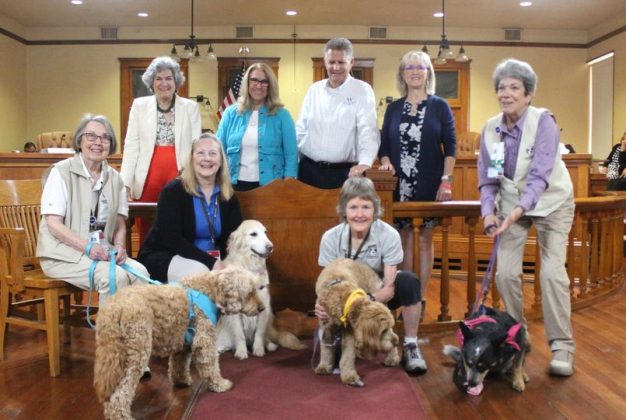 Williamson County commissioners stand with therapy dogs Bubby, Sage, Molly and Magnolia, with their owners for National Therapy Animals Day at the county courthouse April 30. Photo courtesy of Williamson County.