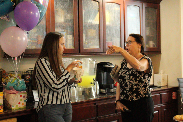 Economic Development Director Traci Anderson, left, and an EDC member enjoy refreshments and snacks to celebrate the library’s birthday.
