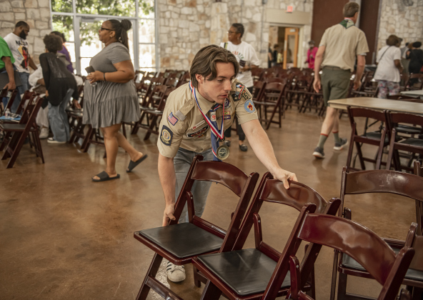 revor Roberts, 19, with Georgetown Boy Scout Troop 151, helps clear chairs to make room for lunch tables after speeches were concluded during the Georgetown Cultural Citizen Memorial Association's 72nd Annual Juneteenth Celebration on Saturday, June 15, 2024.