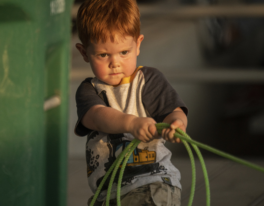 2-year-old Hudson Dewitt, here with his family to watch his big brother Wesson Dewitt, 11, compete in Breakaway Roping, spent some time honing his roping skills from the grandstands  at the 1st Annual Bill Pickett Youth Rodeo, held at the Williamson County Expo Center  on Saturday, June 15, 2024.   The rodeo was open to entrants 18-years-old or younger.    Photo by Andy Sharp