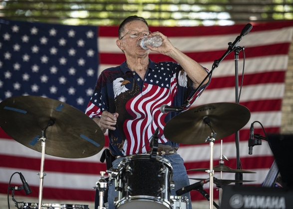 Drummer Jerry Therialt, with the group Vintage Vibes, takes a water hydration break between songs during the 4th of July  celebration  in San Gabriel Park on Thursday, July 4, 2024.  The Georgetown Sertoma Club sponsors the 4th of July Freedom Festival each year in San Gabriel Park.  Photo by Andy Sharp.