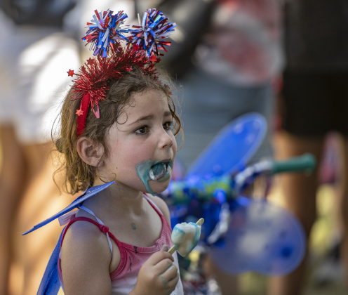 4-year-old Ivy Logan cools off with a cool ice cream treat during the 4th of July celebration in San Gabriel Park on Thursday, July 4, 2024.  The Georgetown Sertoma Club sponsors the 4th of July Freedom Festival each year in San Gabriel Park.  Photo by Andy Sharp.