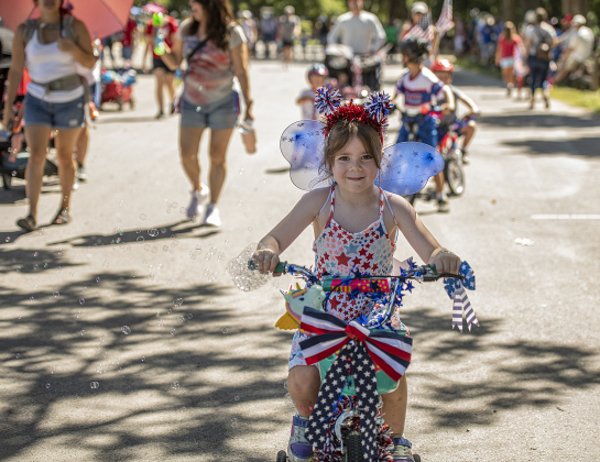 6-year-old Olive Logan rides her bike  in the Hometown Parade in San Gabriel Park on Thursday, July 4, 2024.  The Georgetown Sertoma Club sponsors the 4th of July Freedom Festival each year in San Gabriel Park.  Photo by Andy Sharp.