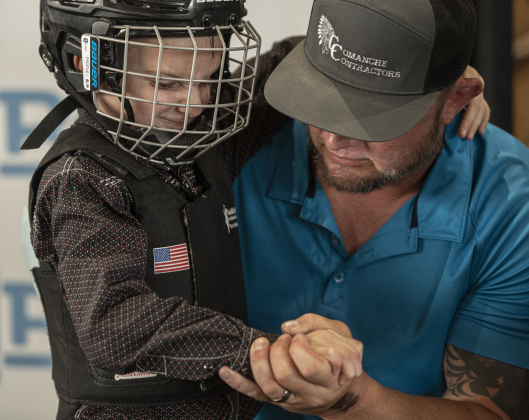 6-year-old Bowen Schneider spends time with his dad Mike Schneider before competing in Mutton Bustin'.