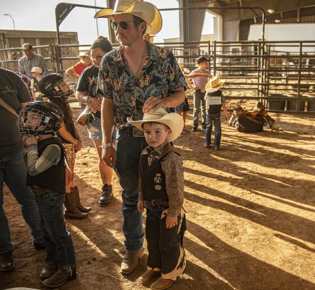 5-year-old Cyrus Fritz, with his dad Ryan Fritz, waits with others to compete in Mutton Bustin'.