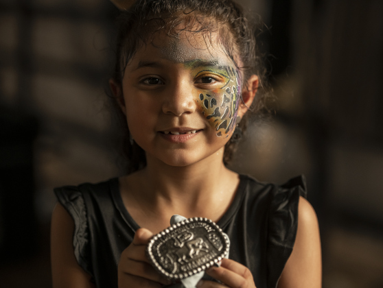 7-year-old Isabella Gutierrez proudly shows the belt buckle she won competing in Mutton Bustin'.