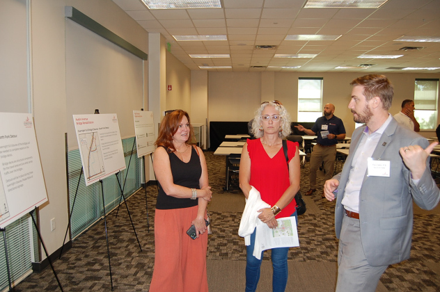 Engineer Paul Hahn, right, speaks to residents about the details of business access and lane closures during a Meet the Contractor event on June 27. (Photo by Kaitlyn Wilkes)