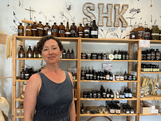 Robin Cervantes, owner of Sanctuary Holistic Kitchen, stands in front of skin care products in the apothecary section
