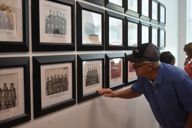 Tony Ziegler examines the wall of graduation photos inside the new building. Mr. Ziegler’s wife, Nancy Turner Ziegler, graduated from the original 1916 Building in 1974