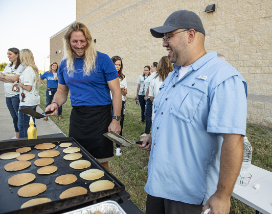 Jesse Lambert, left, husband of San Gabriel Elementary School principal Rebecca Lambert, joins Alex Pazos, right, husband of San Gabriel Elementary Assistant Principal Holly Pazos, as they make pancakes for attendees outside the East View High School gym during the convocation for Georgetown Independent School District staff on Tuesday, August 6, 2024.   Georgetown public schools open on August 15.  Photo by Andy Sharp