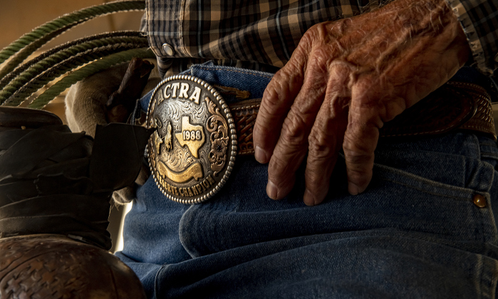77-year-old Harry Fulton of Gatesville, Texas, sits astride his horse named T.R. wearing an American Cowboy Team Roping Association belt buckle awarded to him in 1988.