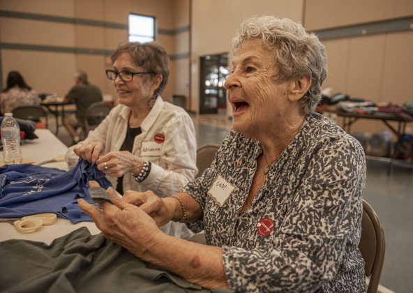 Adrienne Sharp, left, and Cindy Cohen, right, help create bags out of donated t-shirts during a 9/11 National Day of Service event held at Georgetown's Christ Lutheran Church on Saturday, September 7, 2024.  Volunteers from churches, synagogues and mosques, including some who just wanted to contribute, helped repurpose t-shirts to be used as bags at The Caring Place, Helping Hands of Georgetown and the Carver Center for Families.   Photo by Andy Sharp. 