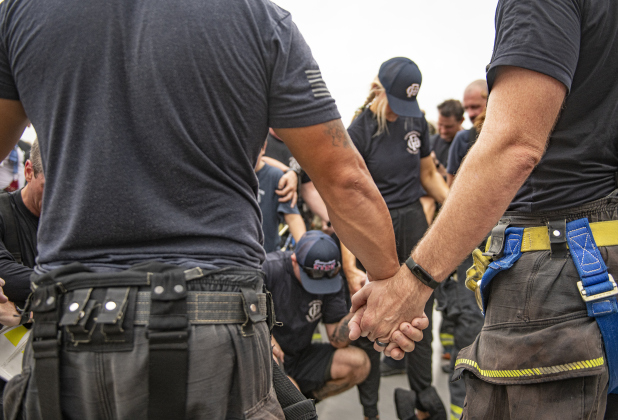 First responders and family members join in prayer at the conclusion of this year's  Memorial Stair Climb at Birkelbach Field on Wednesday, September 11, 2024, the 23rd anniversary of the attacks on United States soil in New York, Pennsylvania and Washington, D.C.  The Memorial Stair Climb began here in 2011.  Photo by Andy Sharp.
