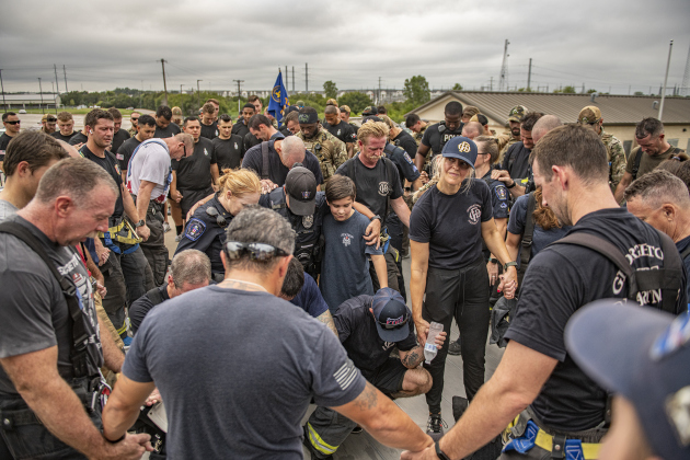 First responders and family members join in prayer at the conclusion of this year's  Memorial Stair Climb at Birkelbach Field on Wednesday, September 11, 2024, the 23rd anniversary of the attacks on United States soil in New York, Pennsylvania and Washington, D.C.   The Memorial Stair Climb began here in 2011.  Photo by Andy Sharp.