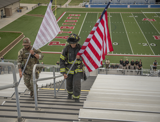 Georgetown Police Department SWAT Team member Nick Onesto, left, and Georgetown Fire Department member Uros Dzelebdzic, right, prepare to post the Flag of Heroes and the American flag to begin the Memorial Stair Climb at Birkelbach Field on Wednesday, September 11, 2024, the 23rd anniversary of the attacks on United States soil in New York, Pennsylvania and Washington, D.C.  The Flag of Heroes contains the names of first responders who lost their lives in the World Trade Center attacks.  The Memorial Stair