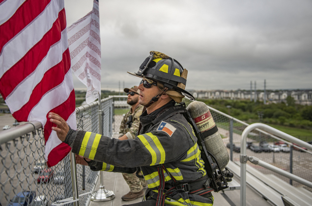 Georgetown Fire Department member Uros Dzelebdzic, front, and Georgetown Police Department SWAT Team member Nick Onesto, post the American flag and the Flag of Heroes at the start of  the Memorial Stair Climb at Birkelbach Field on Wednesday, September 11, 2024, the 23rd anniversary of the attacks on United States soil in New York, Pennsylvania and Washington, D.C.  The Flag of Heroes contains the names of first responders who lost their lives in the World Trade Center attacks.  The Memorial Stair Climb beg