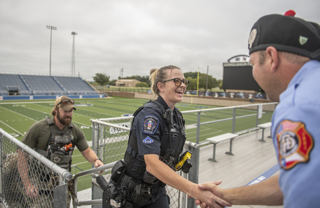 Georgetown Police Department officer Ashley Wall is encouraged by Georgetown Fire Department member Garey Jackson as she continues her efforts during the Memorial Stair Climb at Birkelbach Field on Wednesday, September 11, 2024, the 23rd anniversary of the attacks on United States soil in New York, Pennsylvania and Washington, D.C.  The Memorial Stair Climb began here in 2011.  Photo by Andy Sharp.