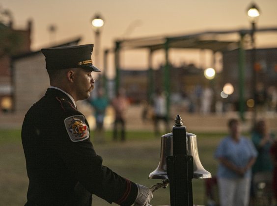 Taylor Fire Department Honor Guard member Brandon Sellears rings the bell to note the passing's of a firefighter  during the Patriot Day observance at Heritage Square Park on Wednesday evening, September 11, 2024.   Patriot Day commemorates the events of September 11, 2001.    Photo by Andy Sharp.