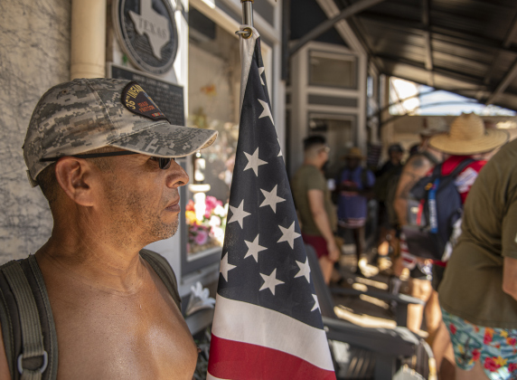 Army veteran Alejandro Martinez takes a brief rest stop along Austin Avenue  before his Irreverent Warriors group continued their 6.1 mile Silkies Hike through Georgetown on Saturday, September 21, 2024.