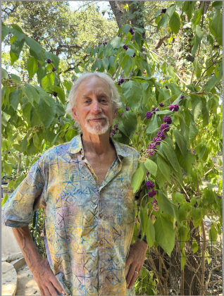 Landscape architect and bird watch guide Martin Byhower stands beside his American beautyberry tree. The tree leaves serve as natural insecticide and birds love to eat the purple berries.