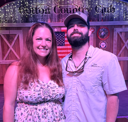 Owners Chris and Emily Hamilton stand in front of the stage at the Cotton Country Club. Photo by Abbey Archer