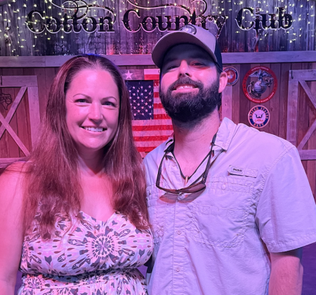Owners Chris and Emily Hamilton stand in front of the stage at the Cotton Country Club. Photo by Abbey Archer