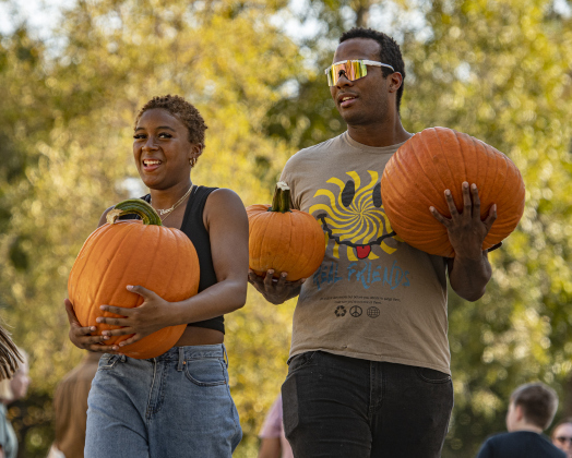 Jurnee Mitchell, 14, a student at East View High School, is joined by her step-father Leland Malry as they unload pumpkins at First United Methodist Church on Wednesday, October 9, 2024.  2,880 large pumpkins, plus many smaller versions were unloaded at the church.   The pumpkins were grown in New Mexico.   A second, but smaller batch of pumpkins will arrive from there on October 19th.   Sales continue through 5p.m. on October 31st.    Photo by Andy Sharp.
