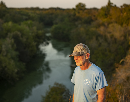 Joe Plunkett, with the Cemetery Restoration Volunteers,  takes in a view of the San Gabriel River that flows near  the circa 1851 McFadin Cemetery on Tuesday, October 8, 2024. Plunkett and his group led the effort to restore this cemetery near the San Gabriel River in recent years.     Photo by Andy Sharp.