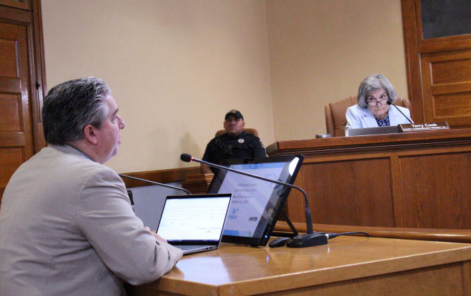 Williamson County District Attorney Shawn Dick, left, answers questions about the funding for the positions during the October 15 Commissioners Court meeting. Photo by Nalani Nuylan.