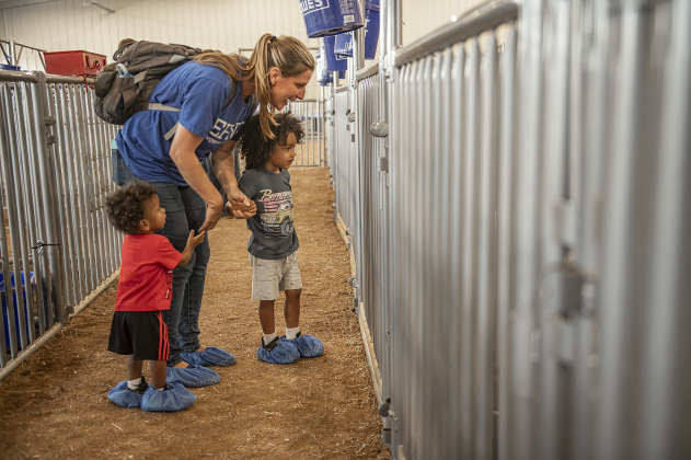 Jani Morachel, a teacher at Georgetown High School, enjoys looking at some of the sheep and goats with her sons, including Jadon, one-and-a-half years old, left, and Caleb, 3, during the Grand Opening of Georgetown High School's new Ag barn on Wednesday, September 25, 2024.   Photo by Andy Sharp.