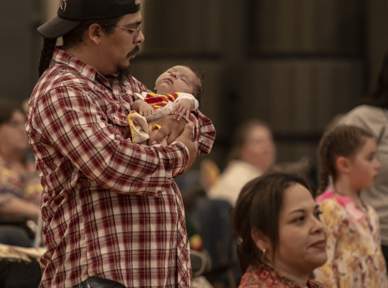 Benjamin Nava cradles his 2-month-old daughter Ariyah Sage Nava while taking part in  the 2024 Georgetown Powwow, held Saturday, September 28, 2024 at the Boys and Girls Club of Georgetown.  Sponsored by GTX Connect, this is Georgetown's first Powwow since the event  was last held at Southwestern University in 2019.  Photo by Andy Sharp.