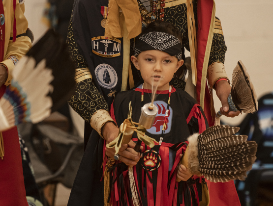 5-year-old Elijah Abrego receives guidance from his father Nathan Abrego while their Lipan Apache family dances during the 2024 Georgetown Powwow, held Saturday, September 28, 2024 at the Boys and Girls Club of Georgetown. Elijah is also called Two Paws while his father uses the name Nate Strong Horse.  Sponsored by GTX Connect, this is Georgetown's first Powwow since the event  was last held at Southwestern University in 2019.  Photo by Andy Sharp.