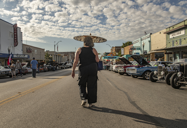 Regina Jones utilizes a parasol to ward off the sun's warm rays as she strolls along closed-off  Main Street to admire vehicles on display during Taylor's Main Street Car Show on Saturday, October 26, 2024.    Photo by Andy Sharp. 